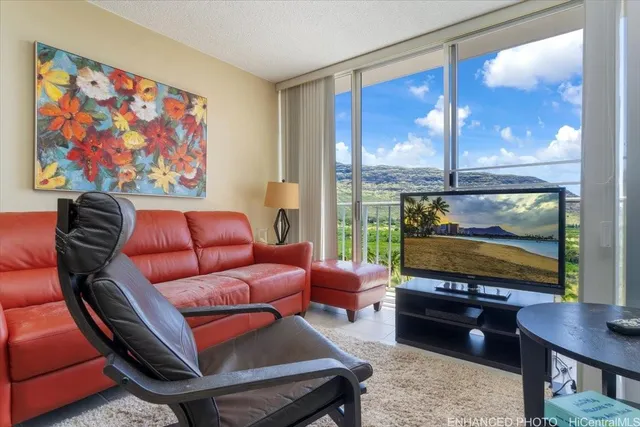 a living room with furniture a flat screen tv and a floor to ceiling window