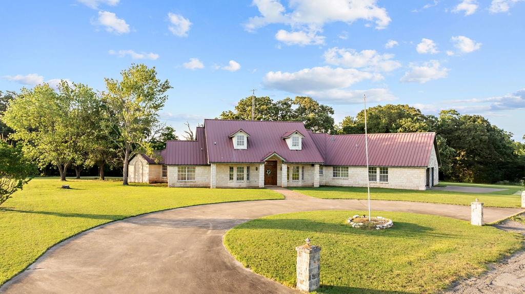 a view of an swimming pool with a yard and large tree