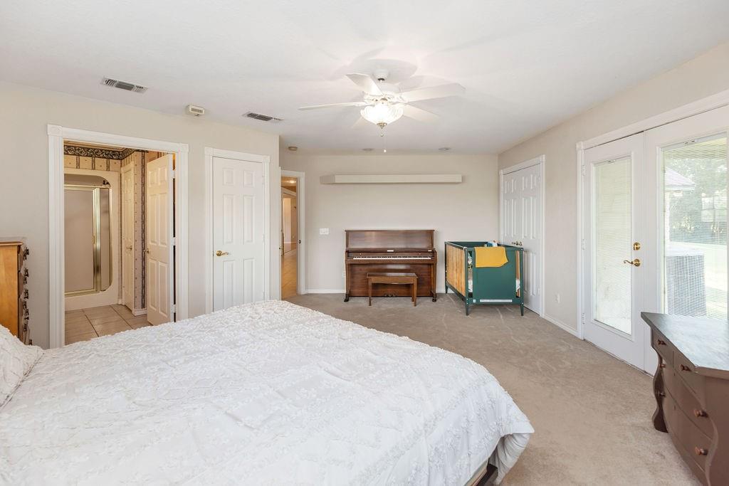 2290 County Road Honey Grove, TX 75446 - Photo 18 of 37 a spacious bedroom with a bed a table and chair