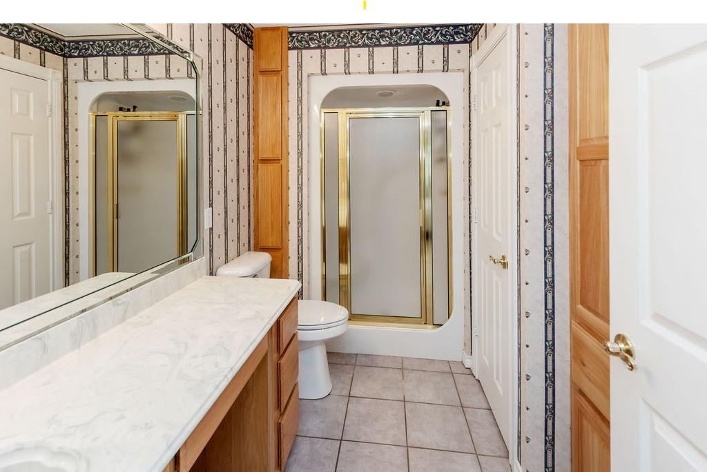 2290 County Road Honey Grove, TX 75446 - Photo 19 of 37 a bathroom with a granite countertop sink a toilet and a mirror