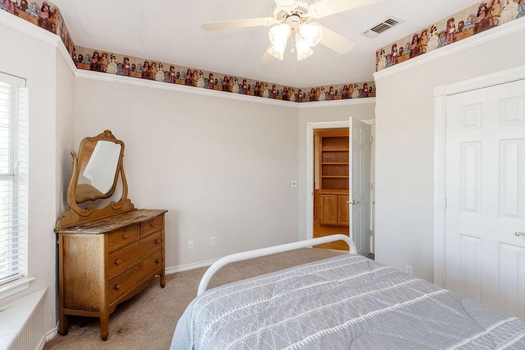 2290 County Road Honey Grove, TX 75446 - Photo 23 of 37 a bedroom with a bed and a chandelier