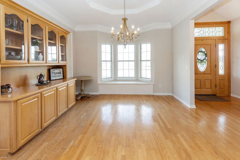 2290 County Road Honey Grove, TX 75446 - Photo 7 of 37 a view of an empty room with window and wooden floor