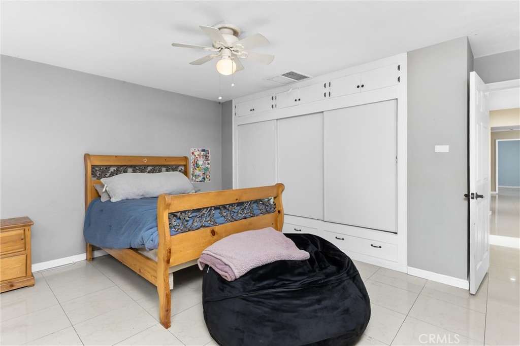 13447 Iroquois Road Apple Valley, CA 92308 - Photo 20 of 45 a bedroom with a bed and a ceiling fan