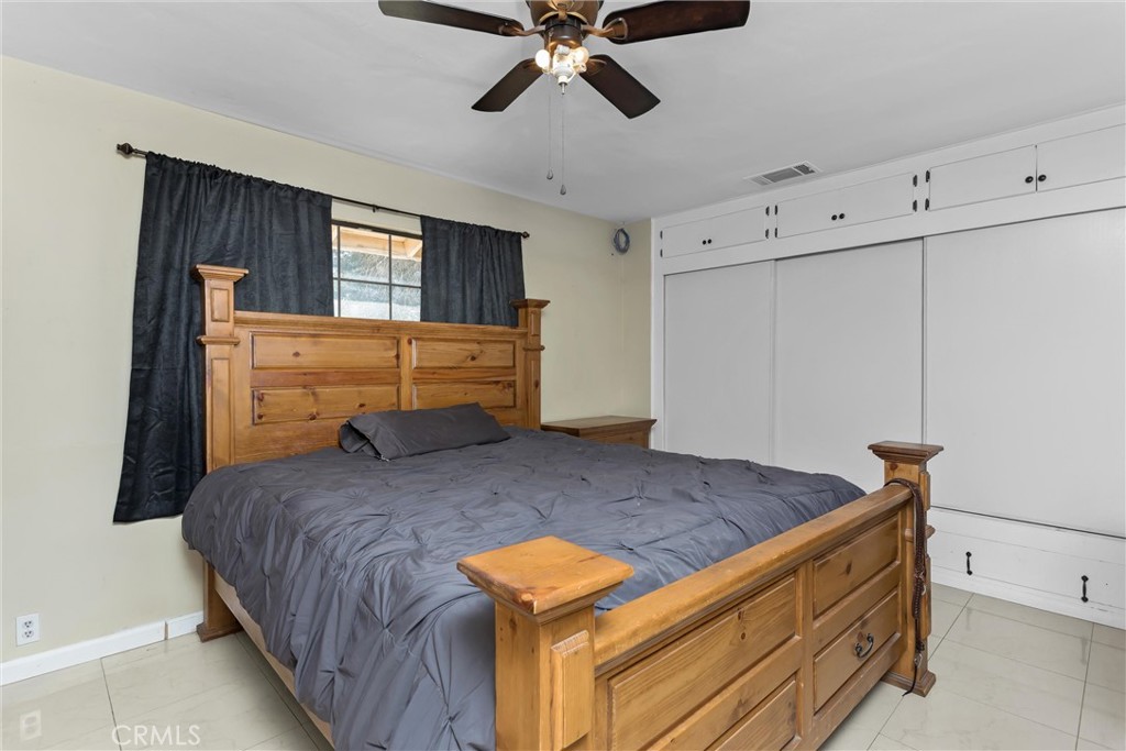 13447 Iroquois Road Apple Valley, CA 92308 - Photo 23 of 45 a bedroom with a bed and a chandelier