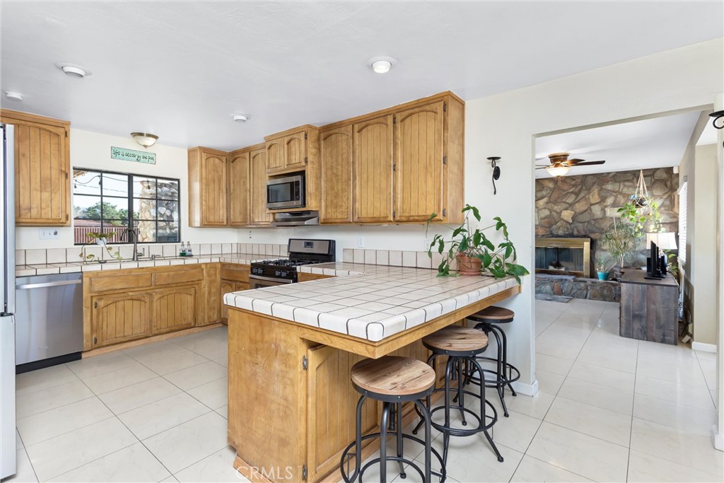 13447 Iroquois Road Apple Valley, CA 92308 - Photo 8 of 45 a kitchen with a stove a sink a oven a dining table and chairs