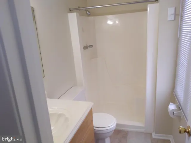 a white toilet sitting next to a shower