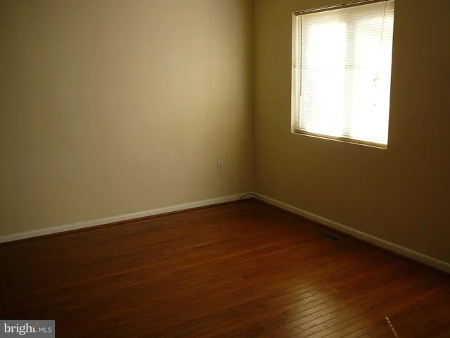 a view of a small space with wooden floor and a window