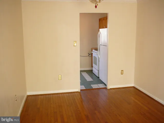 an empty room with wooden floor and a window