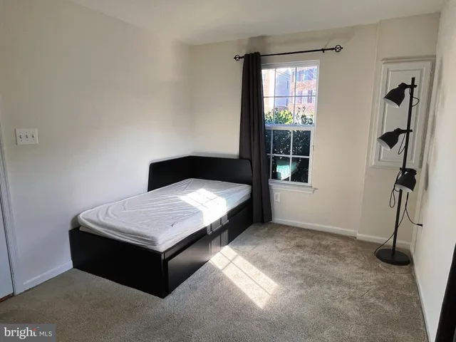 a bed sitting in a room next to a window