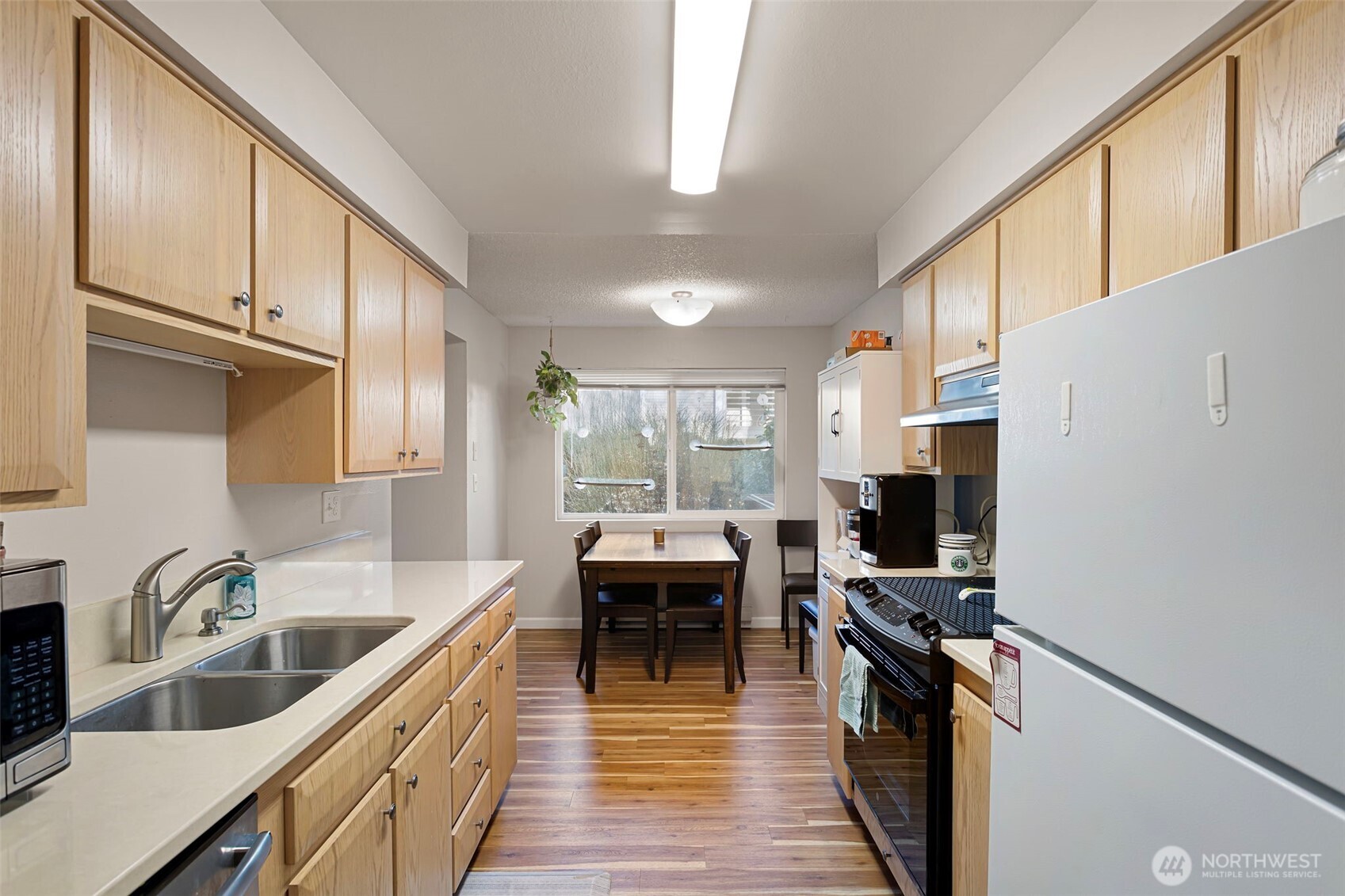 17301 Northeast 45th Street, Unit 87 Redmond, WA 98052 - Photo 10 of 20 a kitchen with kitchen island a counter top space a sink stainless steel appliances and cabinets