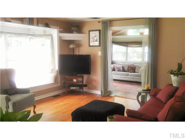 313 Pine Tree Road Oxford, NC 27565 - Photo 2 of 17 Lots of light coming into the living room from the bay window and seat, view into the sunroom/family room with cedar cathedral ceiling and unique paper bag flooring that is amazing and almost unbelieveable. Low maintenance for sure!