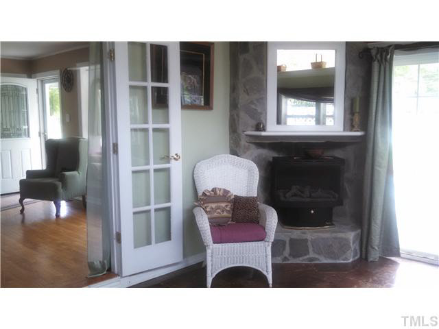 313 Pine Tree Road Oxford, NC 27565 - Photo 3 of 17 Corner fireplace in family/sunroom, view back into the living room gorgeous hardwoods!