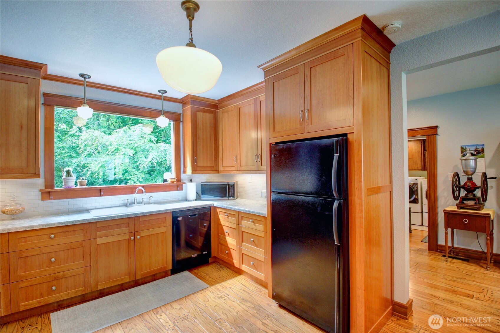 2909 Overpass Road Bow, WA 98232 - Photo 19 of 40 a kitchen with stainless steel appliances granite countertop a refrigerator a sink dishwasher a stove and a dining table with wooden floor