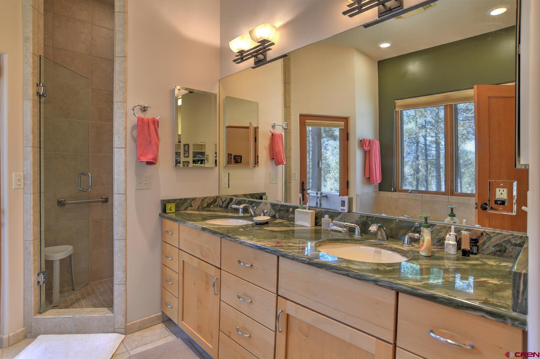 95 Puma Place Durango, CO 81301 - Photo 18 of 45 a bathroom with a granite countertop double vanity sink a mirror and a shower
