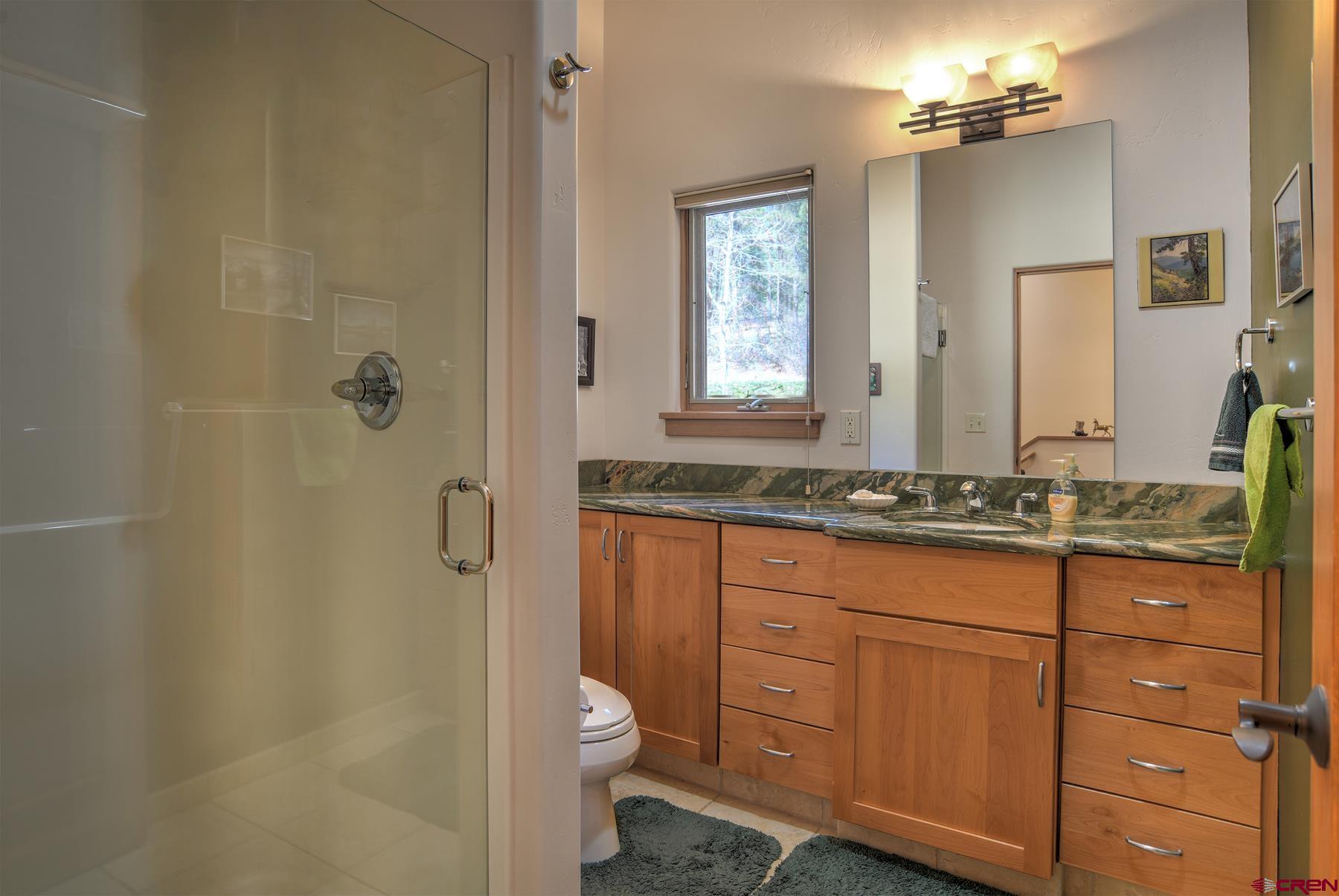 95 Puma Place Durango, CO 81301 - Photo 22 of 45 a bathroom with a granite countertop sink toilet and shower