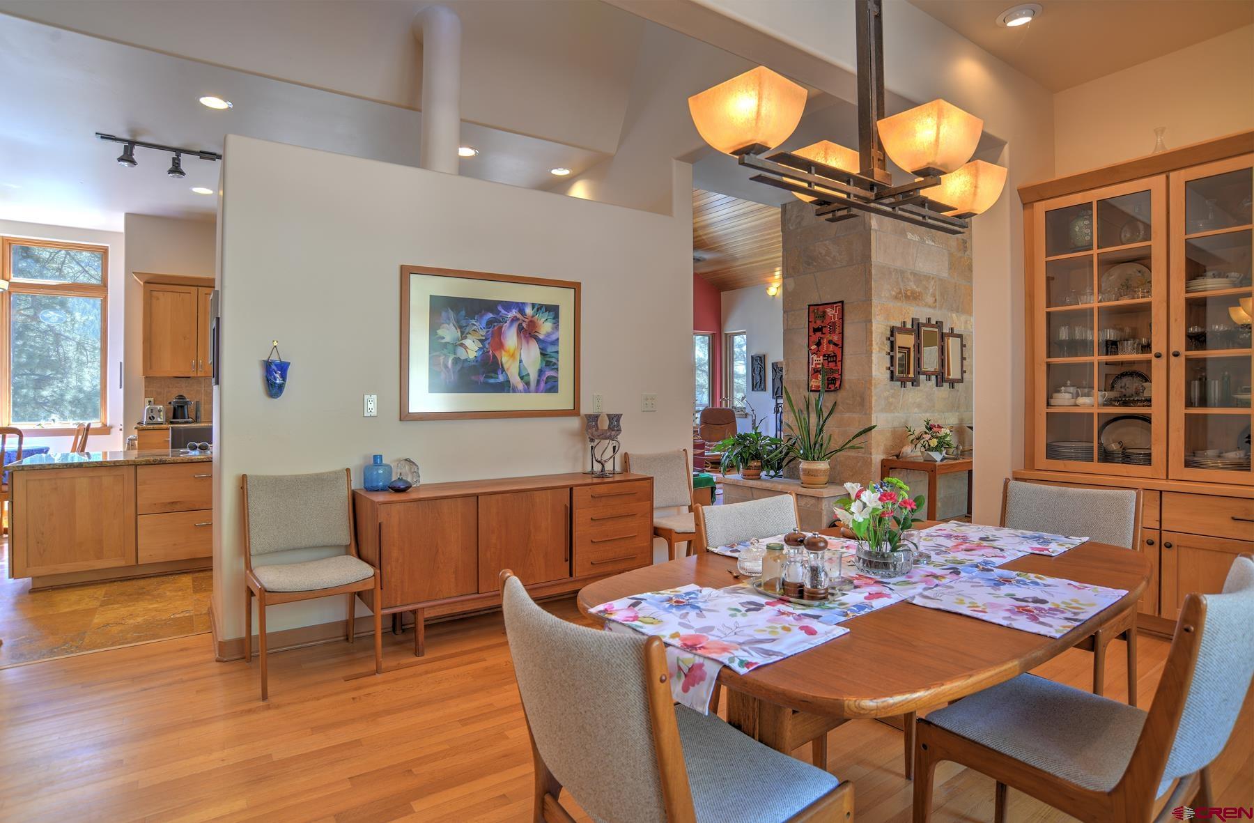 95 Puma Place Durango, CO 81301 - Photo 6 of 45 a dining room with wooden floor a chandelier a wooden table and chairs