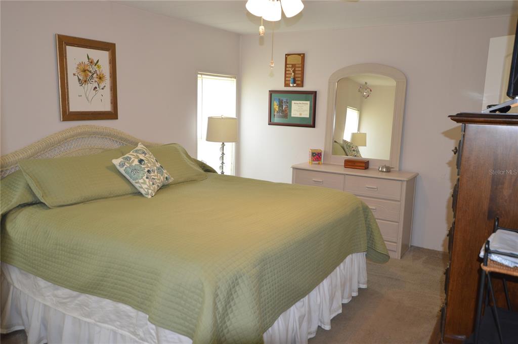 140 Rarotonga Road North Port, FL 34287 - Photo 17 of 42 a bedroom with a bed a dresser and painting on the wall