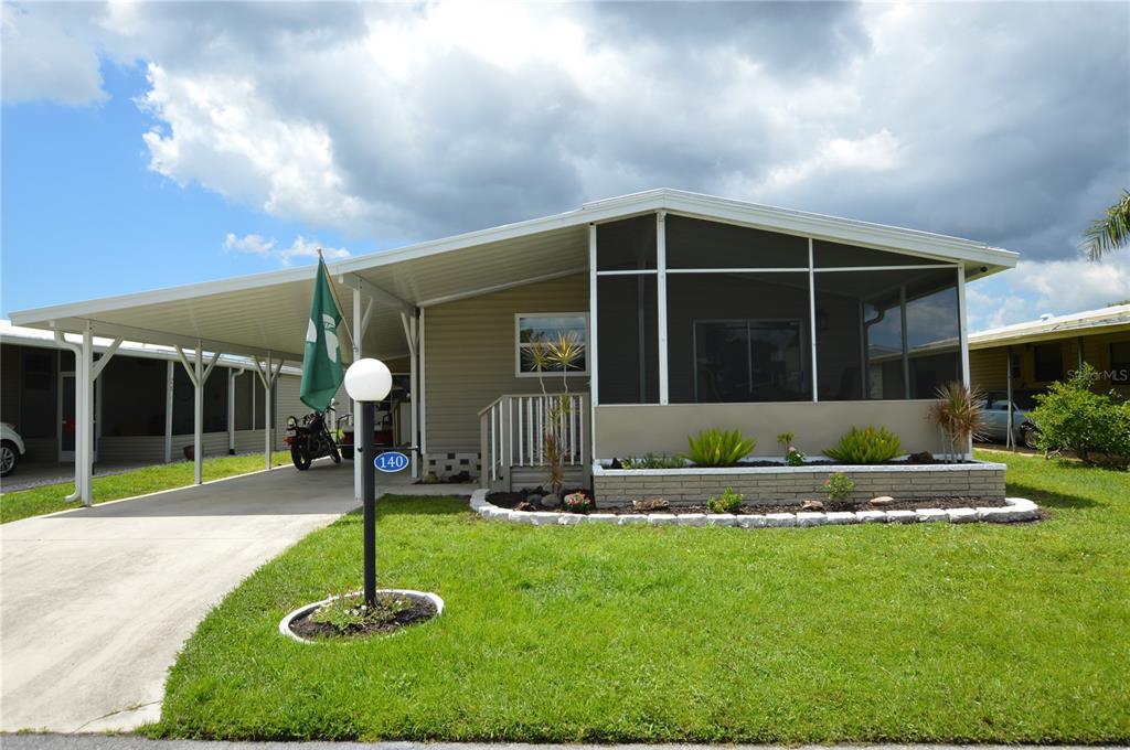 140 Rarotonga Road North Port, FL 34287 - Photo 2 of 42 a front view of a house with a garden