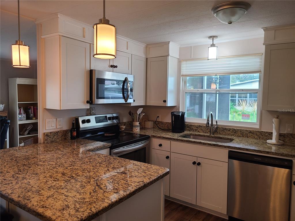 140 Rarotonga Road North Port, FL 34287 - Photo 9 of 42 a kitchen with a sink a stove and cabinets