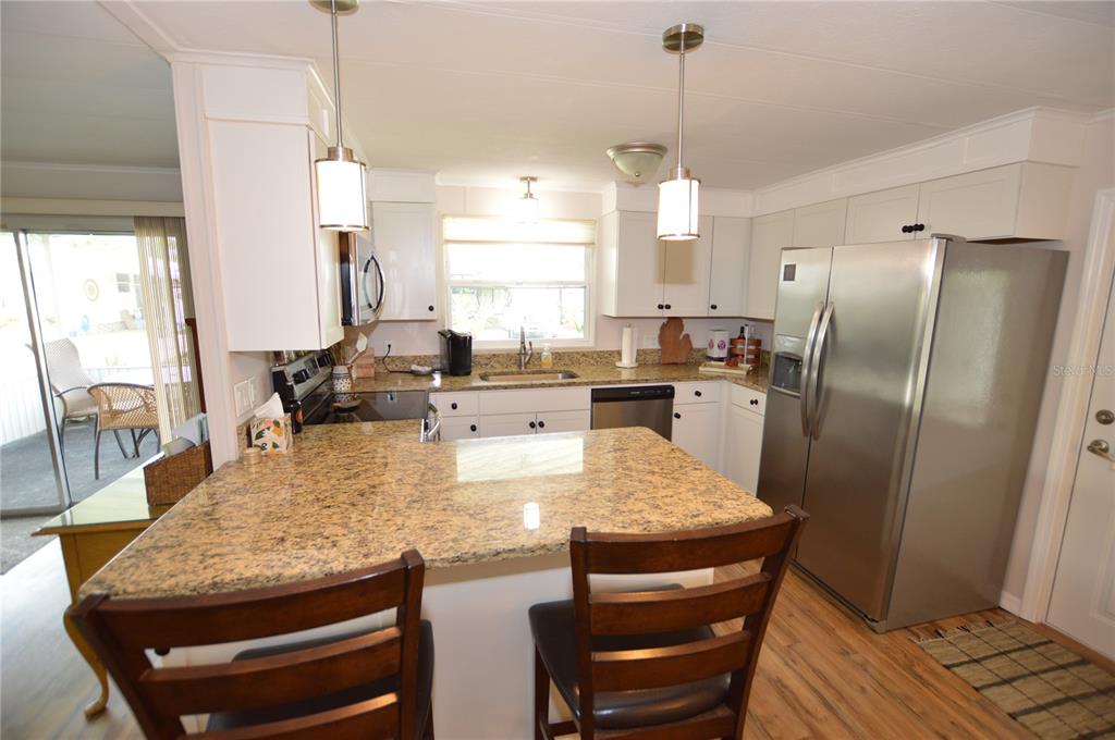 140 Rarotonga Road North Port, FL 34287 - Photo 10 of 42 a kitchen with stainless steel appliances granite countertop a table chairs and a refrigerator
