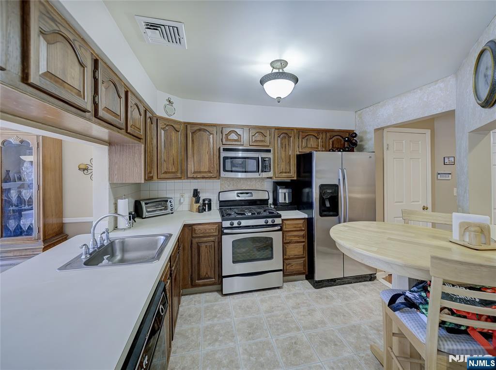 101 Quartz Lane Paterson, NJ 07501 - Photo 29 of 34 a kitchen with stainless steel appliances granite countertop a sink stove and refrigerator