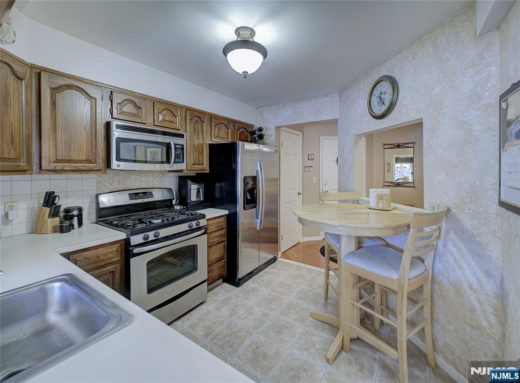 101 Quartz Lane Paterson, NJ 07501 - Photo 31 of 34 a kitchen with stainless steel appliances granite countertop a stove top oven a sink and cabinets