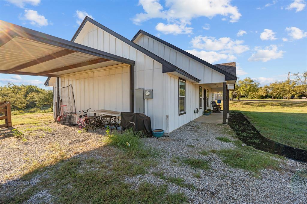 509 Pecan Tree Court Poolville, TX 76487 - Photo 23 of 25 a view of a house with backyard and sitting area