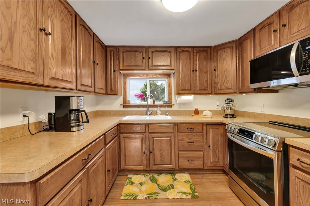 8704 Columbia Road Olmsted Falls, OH 44138 - Photo 2 of 34 U-shaped kitchen with wood-finish cabinetry and light-toned countertops