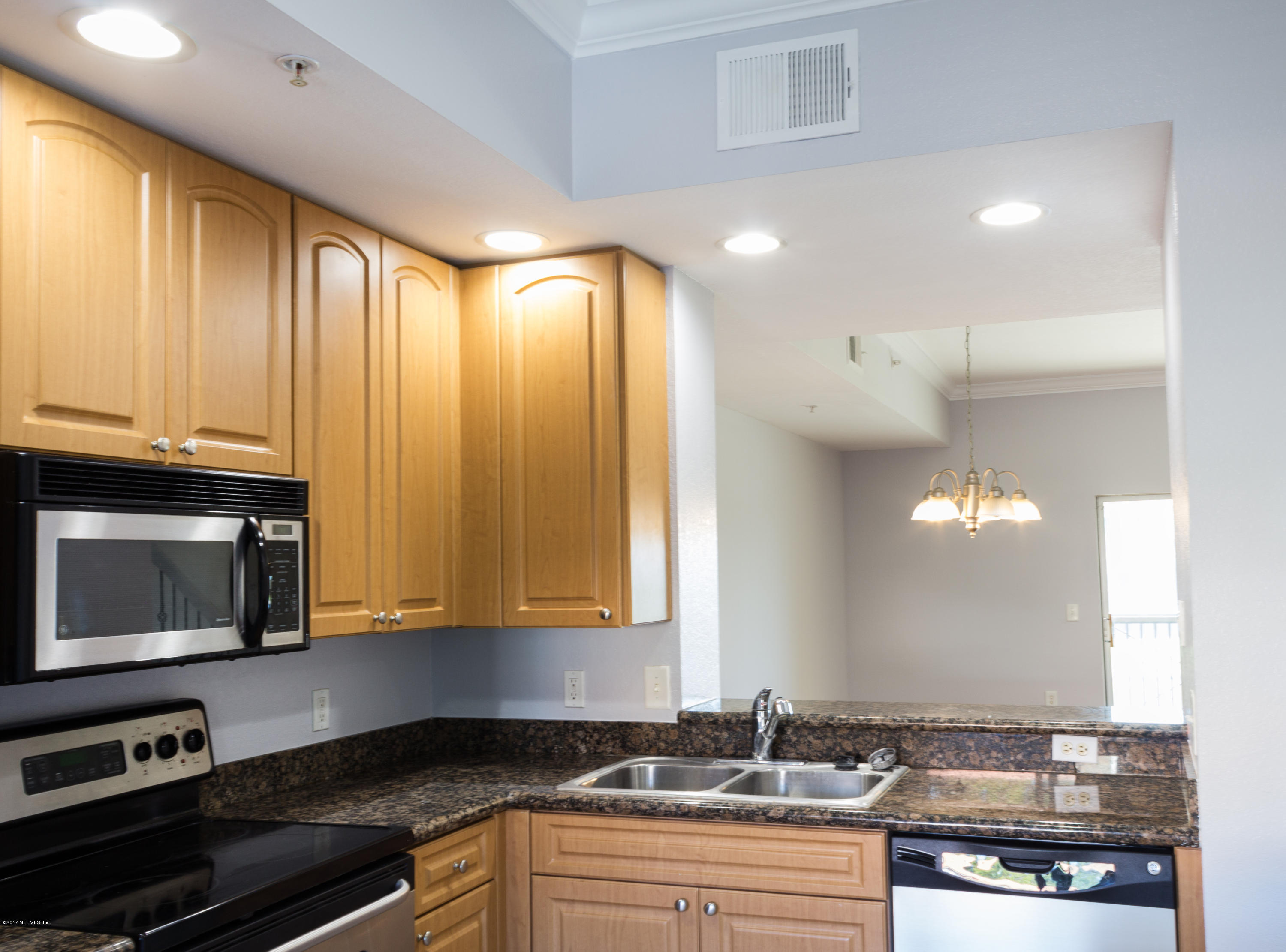 9745 Touchton Road, Unit 1828 Jacksonville, FL 32246 - Photo 5 of 26 a kitchen with stainless steel appliances granite countertop a stove a sink and a microwave