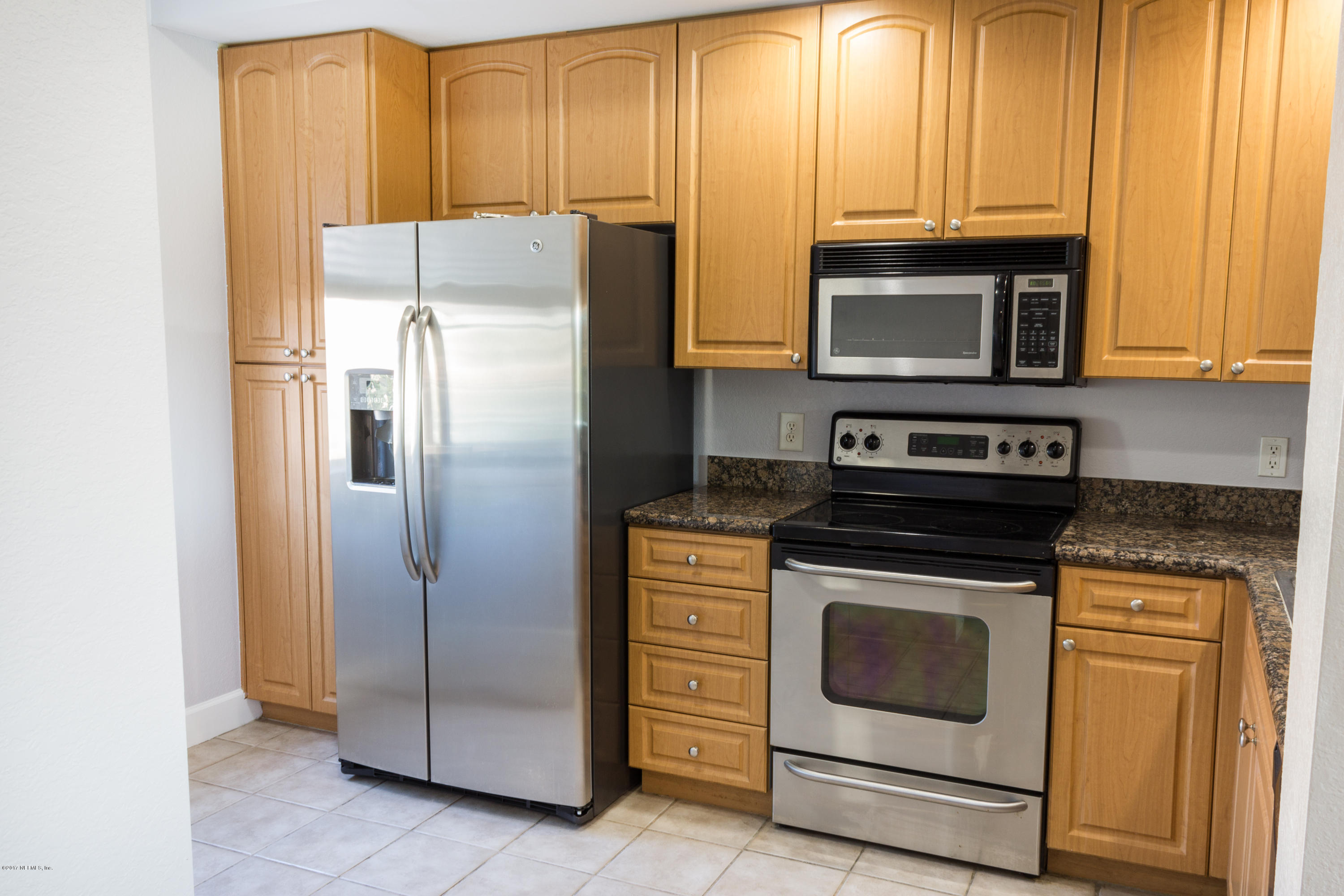 9745 Touchton Road, Unit 1828 Jacksonville, FL 32246 - Photo 6 of 26 a kitchen with granite countertop cabinets stainless steel appliances and a window