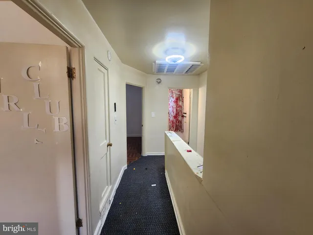 a hallway with front door wooden floor and chandelier