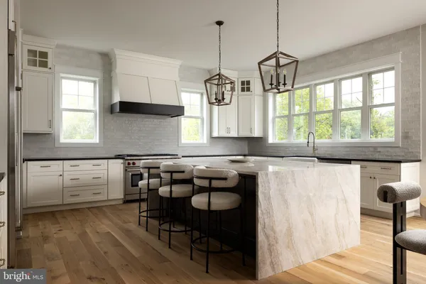 a kitchen with kitchen island granite countertop a stove a sink a dining table and chairs with wooden floor