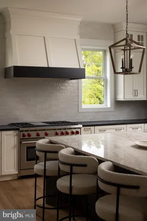 a kitchen with a stove a table and chairs in it
