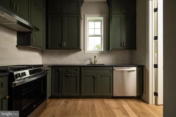 a kitchen with granite countertop a stove and cabinets