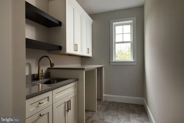a kitchen with stainless steel appliances granite countertop white cabinets and window