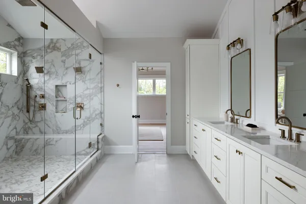 a spacious bathroom with a double vanity sink mirror and shower