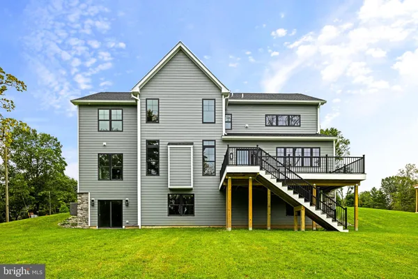 a view of a house with a big yard and large trees