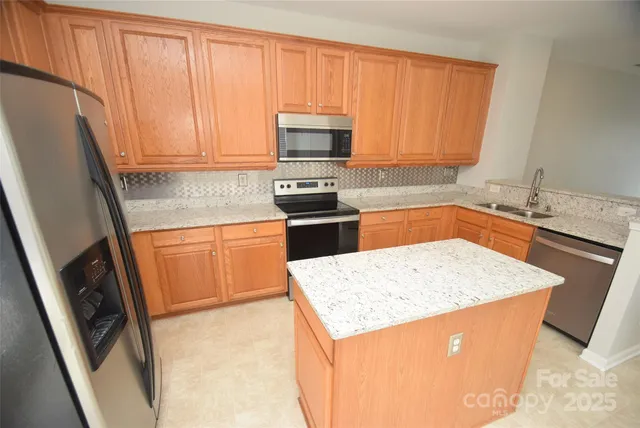 a kitchen with granite countertop a sink stove and refrigerator