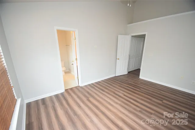 a view of a room with wooden floor and a hallway