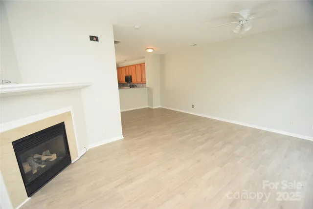 an empty room with wooden floor and fireplace