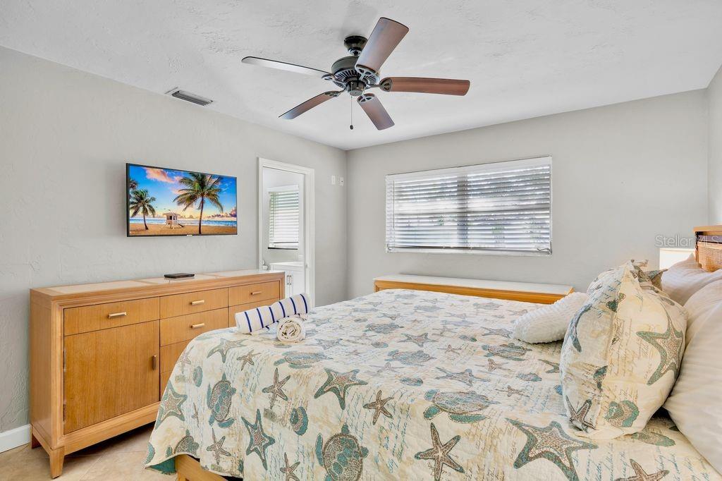 5830 Midnight Pass Road, Unit 107 Sarasota, FL 34242 - Photo 13 of 18 a bedroom with a bed and a chandelier