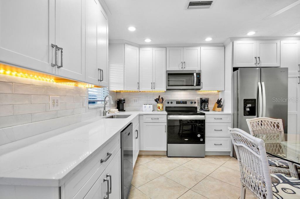 5830 Midnight Pass Road, Unit 107 Sarasota, FL 34242 - Photo 4 of 18 a kitchen with a sink stove and refrigerator