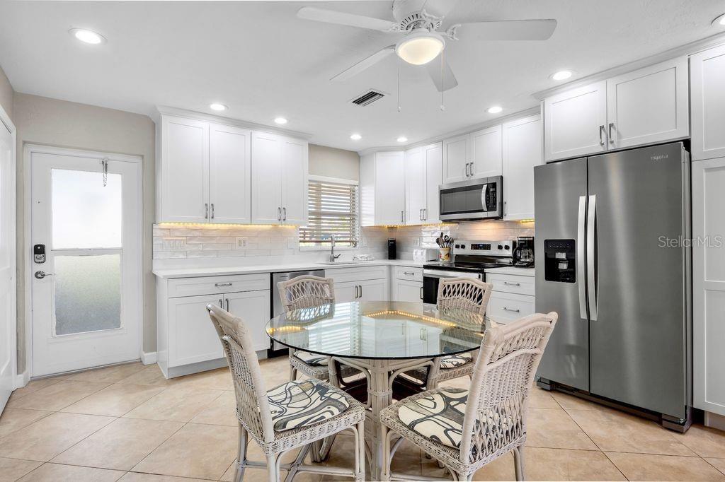 5830 Midnight Pass Road, Unit 107 Sarasota, FL 34242 - Photo 5 of 18 a kitchen with refrigerator a sink and a refrigerator