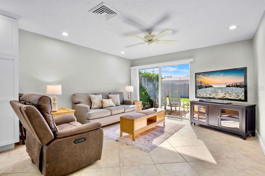 5830 Midnight Pass Road, Unit 107 Sarasota, FL 34242 - Photo 6 of 18 a living room with furniture and a flat screen tv