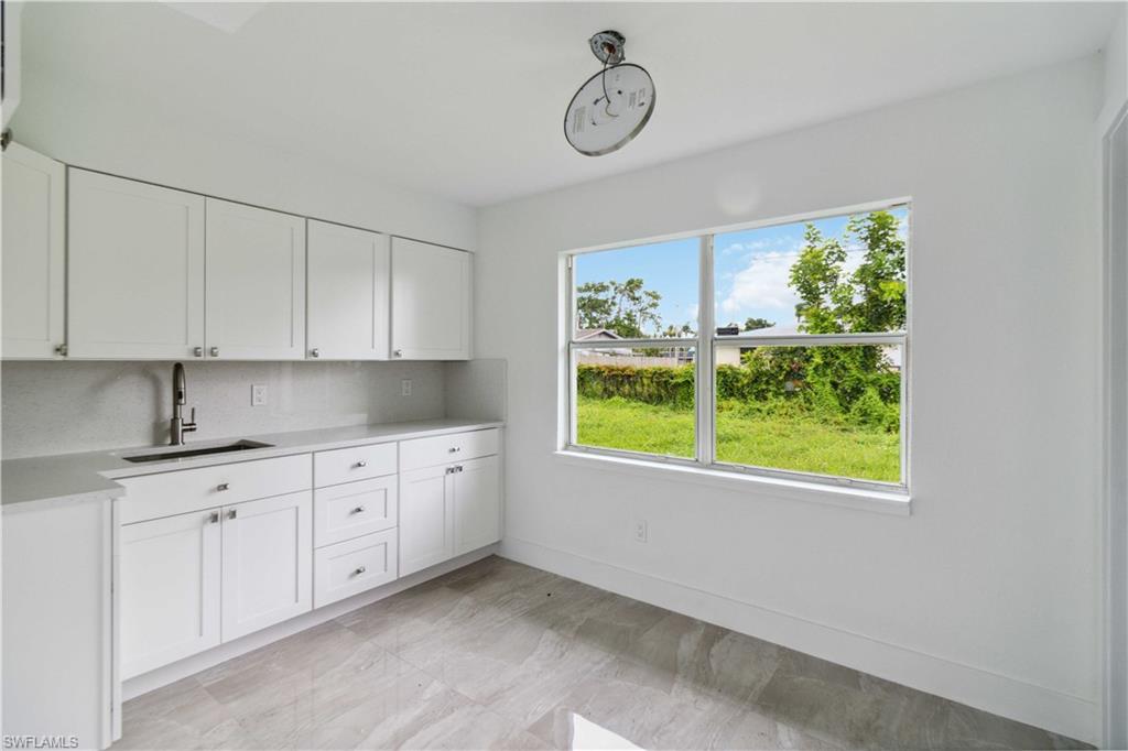 1102 East Bougainvillea Road Lehigh Acres, FL 33936 - Photo 13 of 28 a kitchen with a window a sink and a window