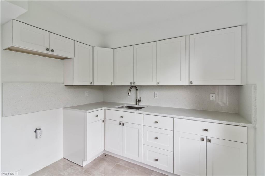 1102 East Bougainvillea Road Lehigh Acres, FL 33936 - Photo 14 of 28 a kitchen with white cabinets