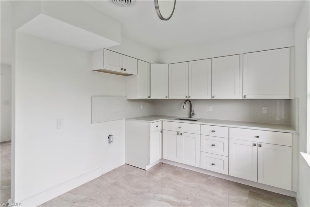 1102 East Bougainvillea Road Lehigh Acres, FL 33936 - Photo 15 of 28 a kitchen with white cabinets