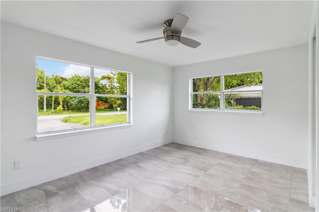 1102 East Bougainvillea Road Lehigh Acres, FL 33936 - Photo 17 of 28 a view of an empty room with a window and kitchen view