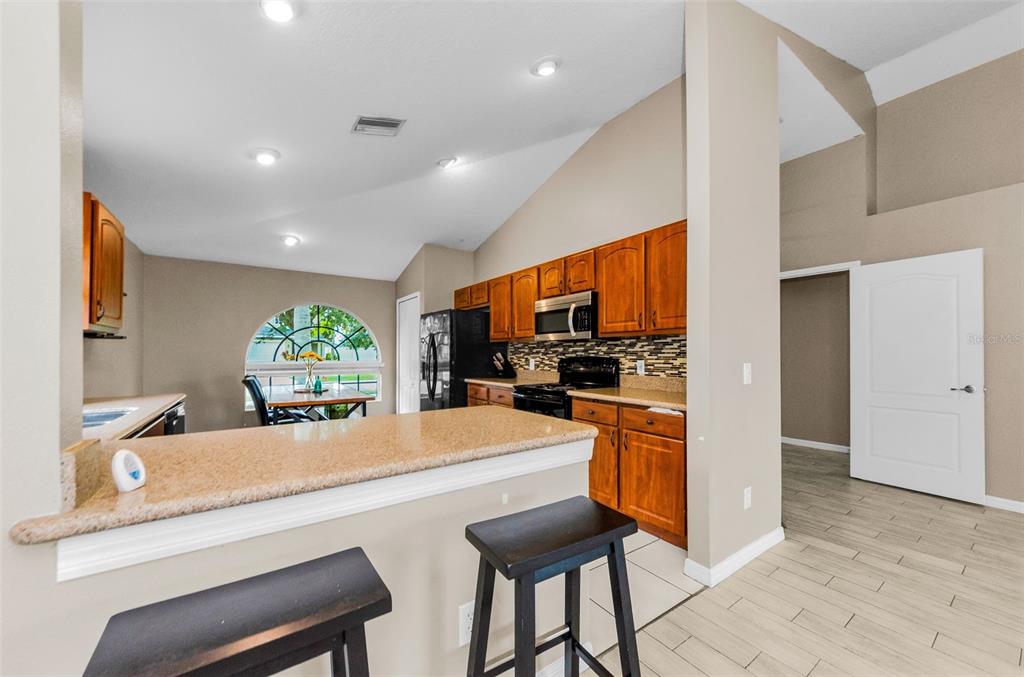 13561 Fladgate Mark Drive Riverview, FL 33579 - Photo 12 of 65 a kitchen with stainless steel appliances kitchen island granite countertop a refrigerator and a sink