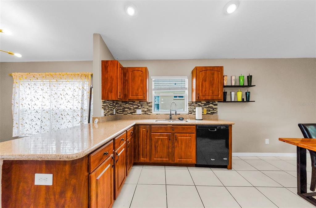 13561 Fladgate Mark Drive Riverview, FL 33579 - Photo 13 of 65 a large kitchen with granite countertop a sink and a stove top oven